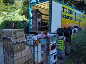Un camion de déménagement ouvert en train d'être chargé de matériel varié type electro ménager